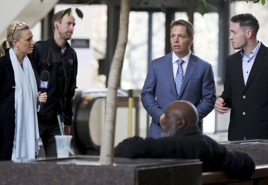 CORRECTS THAT DON DAMOND WAS JUSTINE RUSZCZYK'S FIANCE, NOT HUSBAND AND THAT ZACH DAMOND IS NOT RUSZCZYK'S SON - Media members approach Don Damond, the fiance of Justine Ruszczyk Damond, second from right, and Zach Damond, right, Don Damond's son, as they arrive for the opening arguments in the trial of former Minneapolis police officer Mohamed Noor at the Hennepin County Government Center for Tuesday, April 9, 2019, in Minneapolis. (David Joles/Star Tribune via AP)