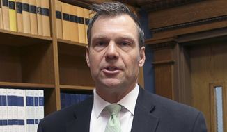 In this Nov. 30, 2018, photo, then-Kansas Secretary of State Kris Kobach responds to questions from reporters in Topeka, Kan. (AP Photo/John Hanna) **FILE**