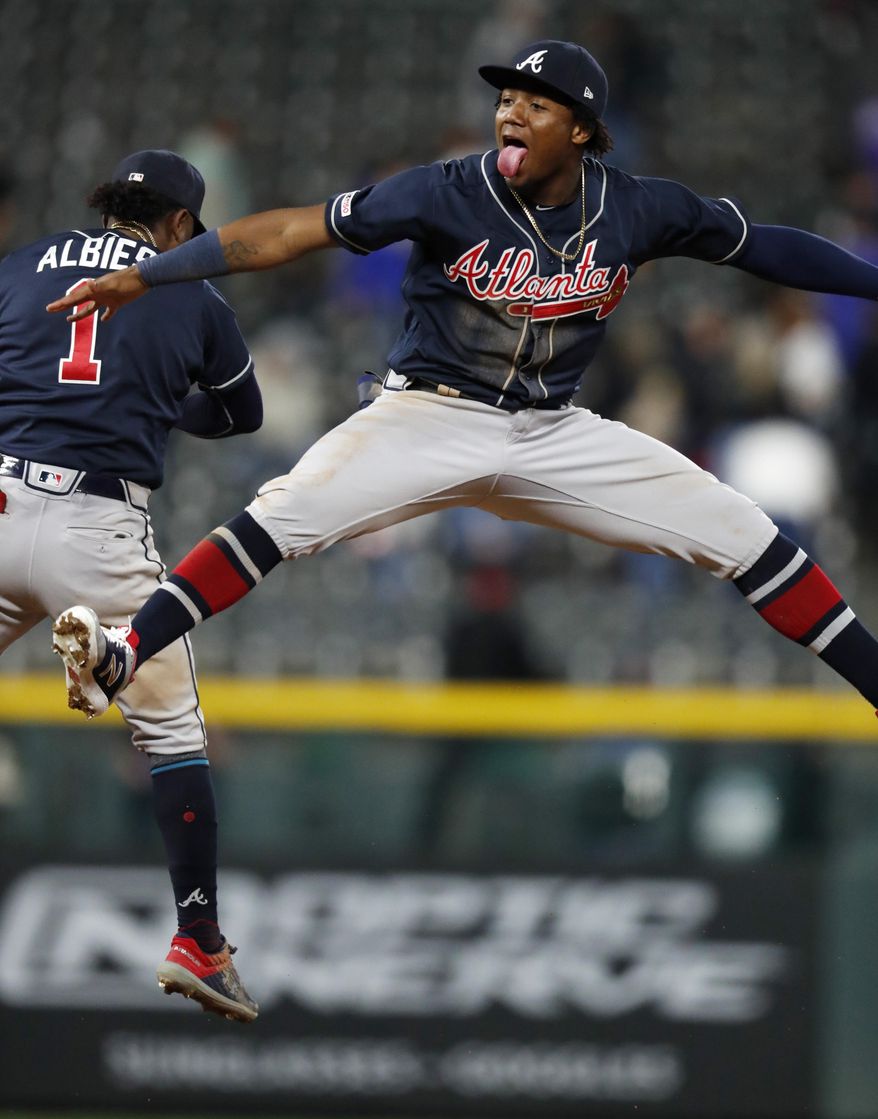 Atlanta Braves left fielder Ronald Acuna Jr., front, celebrates with second baseman Ozzie Albies after the team&#39;s baseball game against the Colorado Rockies on Tuesday, April 9, 2019, in Denver. The Braves won 7-1. (AP Photo/David Zalubowski)