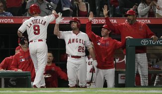 Los Angeles Angels&#39; Tommy La Stella, left, high-fives teammates to celebrate his home run during the fourth inning of a baseball game against the Milwaukee Brewers, Tuesday, April 9, 2019, in Anaheim, Calif. (AP Photo/Jae C. Hong)