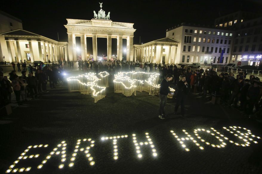 Activists of the World Wide Fund For Nature (WWF) set up led-lights in front of the illuminated Brandenburg Gate to mark Earth Hour, in Berlin, Saturday, March 30, 2019. The global event Earth Hour is the symbolic switching off of the lights for one hour to help minimalize fossil fuel consumption as well as mitigate the effects of climate change. (AP Photo/Markus Schreiber)