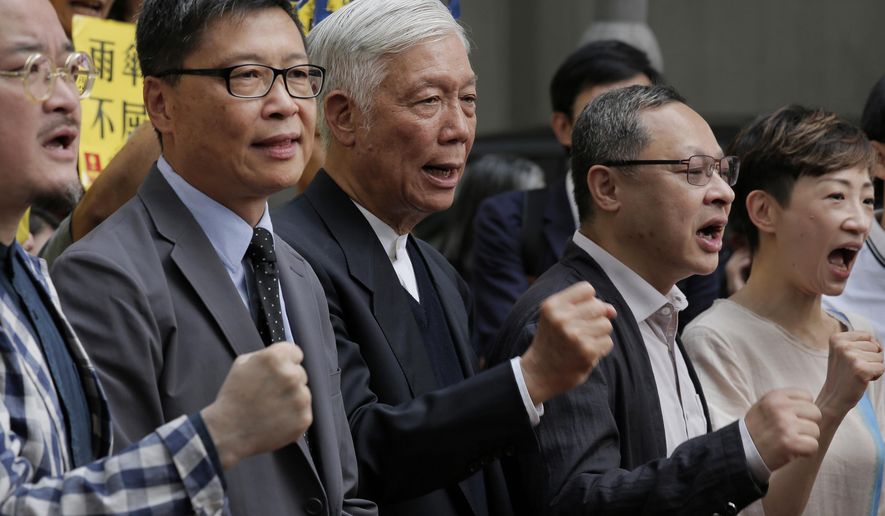 Occupy Central leaders, from left, Shiu Ka-chun, Chan Kin-man, Chu Yiu-ming, Benny Tai and Tanya Chan shout slogans before entering a court in Hong Kong, Wednesday, April 10, 2019. Nine pro-democracy activists returned to court Wednesday in Hong Kong to await their verdicts after having been found guilty of various offenses in relation to the 2014 "Occupy Central" protest, which paralyzed city streets in the southern Chinese territory. (AP Photo/Vincent Yu)