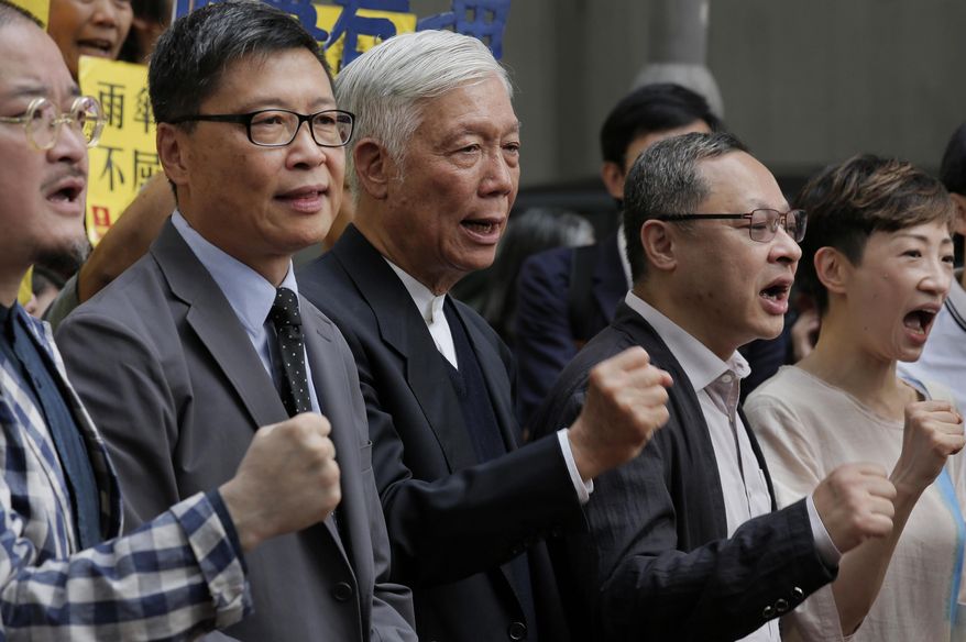 Occupy Central leaders, from left, Shiu Ka-chun, Chan Kin-man, Chu Yiu-ming, Benny Tai and Tanya Chan shout slogans before entering a court in Hong Kong, Wednesday, April 10, 2019. Nine pro-democracy activists returned to court Wednesday in Hong Kong to await their verdicts after having been found guilty of various offenses in relation to the 2014 "Occupy Central" protest, which paralyzed city streets in the southern Chinese territory. (AP Photo/Vincent Yu)