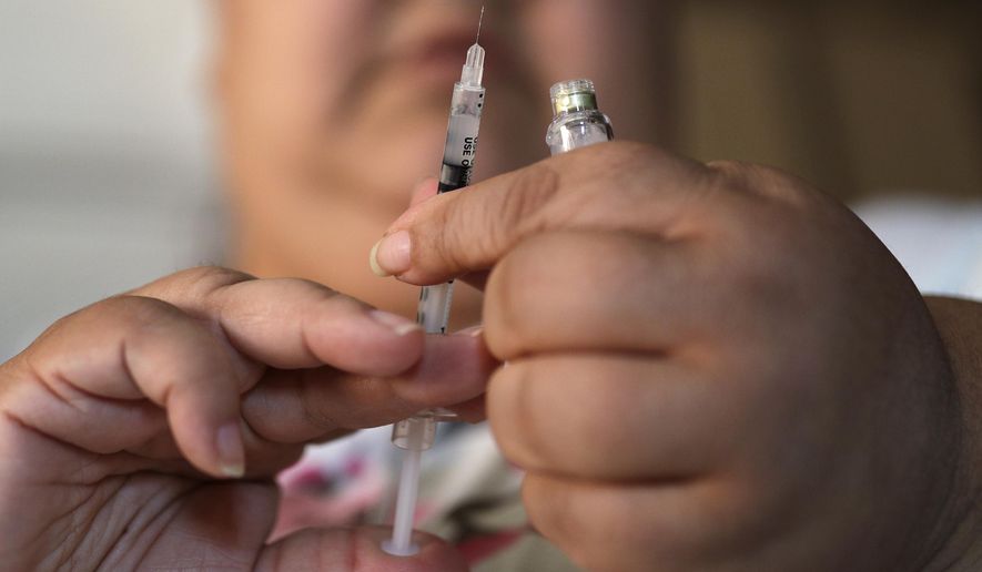 In this April 18, 2017 file photo, a woman with Type 2 diabetes prepares to inject herself with insulin at her home in Las Vegas. The skyrocketing price of insulin has some diabetics scrambling to cover the cost of the life-saving medication. Others are skipping doses or using smaller amounts than needed, and sometimes landing in the ER, patients and advocates told Congress in April 2019. (AP Photo/John Locher)