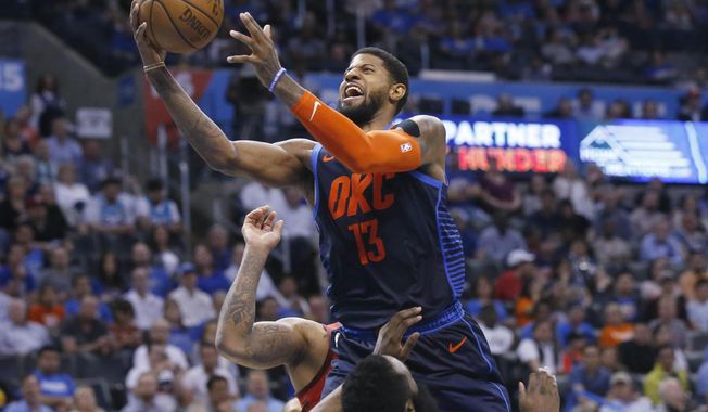 Oklahoma City Thunder forward Paul George (13) collides with Houston Rockets guard James Harden, bottom, and is called for a foul during the second half of an NBA basketball game Tuesday, April 9, 2019, in Oklahoma City. (AP Photo/Sue Ogrocki)