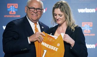 University of Tennessee athletic director Phillip Fulmer passes a jersey to Kellie Harper during a press conference announcing her as the new head coach of the Lady Vols, in the Ray and Lucy Hand Studio on University of Tennessee&#39;s campus Wednesday, April 10, 2019 in Knoxville, Tenn. (Caitie McMekin/Knoxville News Sentinel via AP)