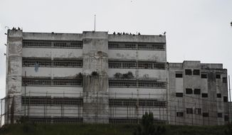 FILE - In this April 28, 2017 file photo, prison guards stand on the roof of the Ramo Verde military prison in Los Teques, on the outskirts of Caracas, Venezuela. The International Committee of the Red Cross has regained access to visit prisons in Venezuela, including highly guarded military facilities such as Ramo Verde where dozens of inmates considered political prisoners are being held. (AP Photo/Ariana Cubillos, File)