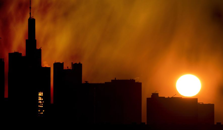 The sun rises over the buildings of the banking district in Frankfurt, Germany, Thursday, April 11, 2019. (AP Photo/Michael Probst)