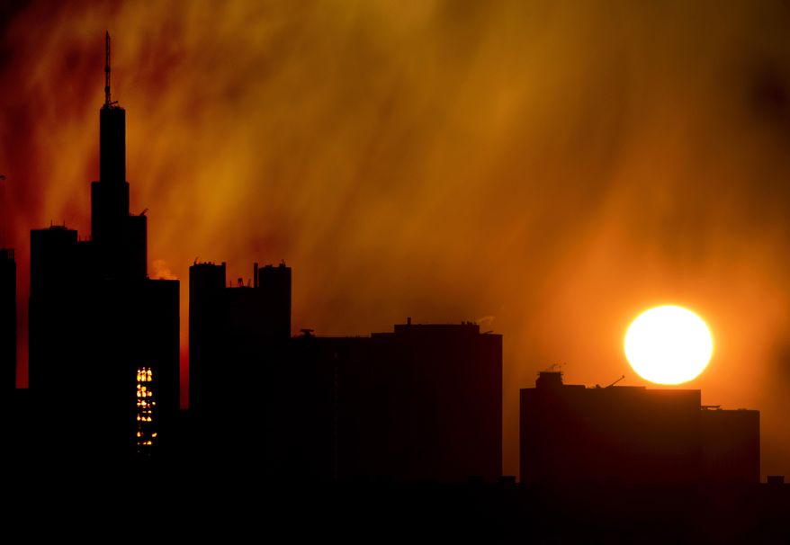 The sun rises over the buildings of the banking district in Frankfurt, Germany, Thursday, April 11, 2019. (AP Photo/Michael Probst)