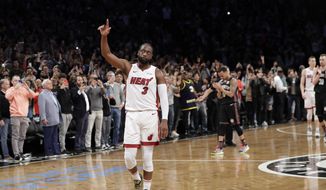 Miami Heat guard Dwyane Wade (3) acknowledges the crowd&#x27;s cheers after playing in the final NBA basketball game of his career, against the Brooklyn Nets on Wednesday, April 10, 2019, in New York. (AP Photo/Kathy Willens) ** FILE **
