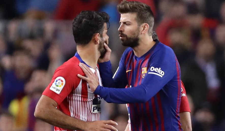 Barcelona's Gerard Pique, right, talks to Atletico forward Diego Costa as he tries to calm him after he was sent off with a red card for insulting referee Jesus Gil Manzano during a Spanish La Liga soccer match between FC Barcelona and Atletico Madrid at the Camp Nou stadium in Barcelona, Spain, Saturday April 6, 2019. (AP Photo/Manu Fernandez)