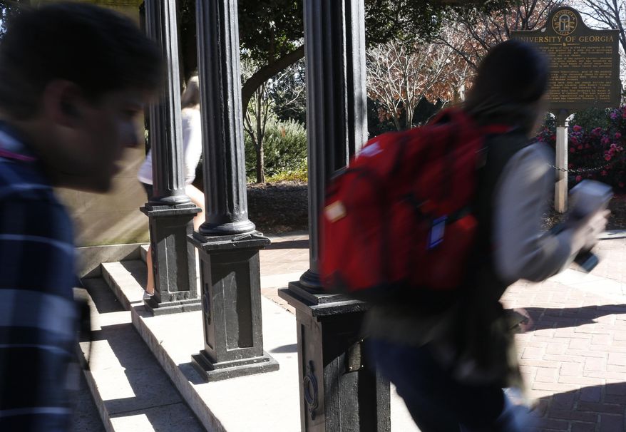 FILE- In this Jan. 9, 2019, file photo University of Georgia undergraduate students avoid walking under the university arch on the first day of the spring semester in Athens, Ga. As the U.S. student loan balance surpasses $1.5 trillion, a trio of contests promise a lucky few a shot at putting a dent in their debt. (Joshua L. Jones/Athens Banner-Herald via AP)
