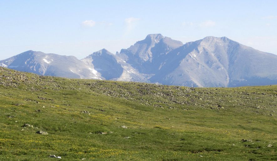 This July 17, 2016, photo shows Longs Peak towering over alpine tundra in Rocky Mountain National Park, Colo. A draft report released Wednesday, April 10, 2019, said harmful nitrogen pollution is still drifting onto fragile high-elevation ecosystems in the park from Colorado highways, power plants and livestock operations. The report, released by the Colorado Department of Public Health and Environment, the U.S. Environmental Protection Agency and the National Park Service, recommended against activating a contingency plan to reduce pollution, saying nitrogen levels did not increase much in the previous decade. (AP Photo/Dan Elliott)