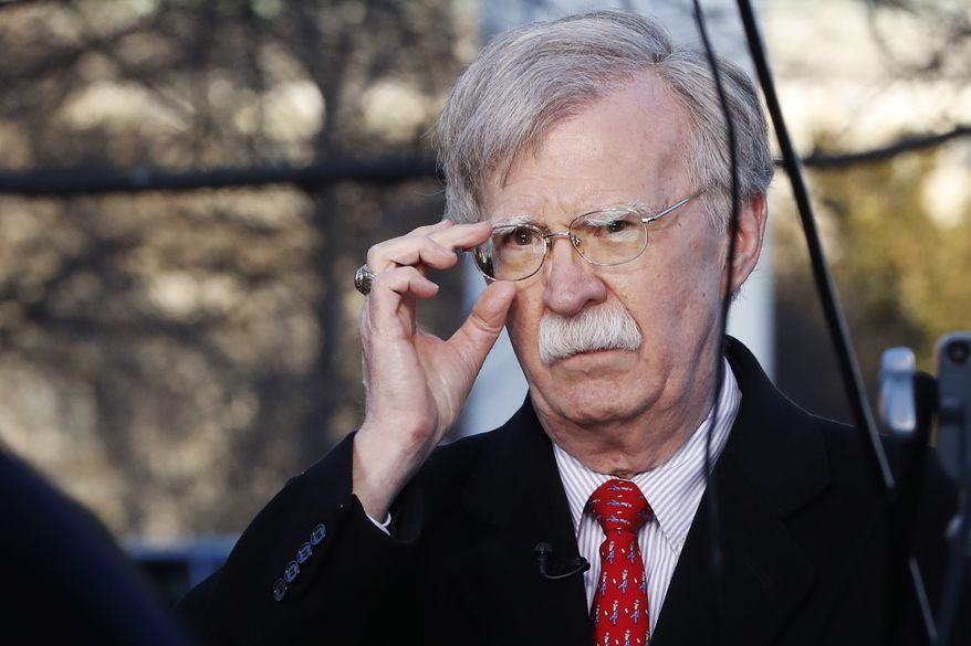 In this March 5, 2019, photo, national security adviser John Bolton adjusts his glasses before an interview at the White House in Washington. Bolton is traveling to Miami next week to outline steps the administration is taking to confront what he says are threats from “the troika of tyranny,” Cuba, Venezuela and Nicaragua. (Associated Press) **FILE**