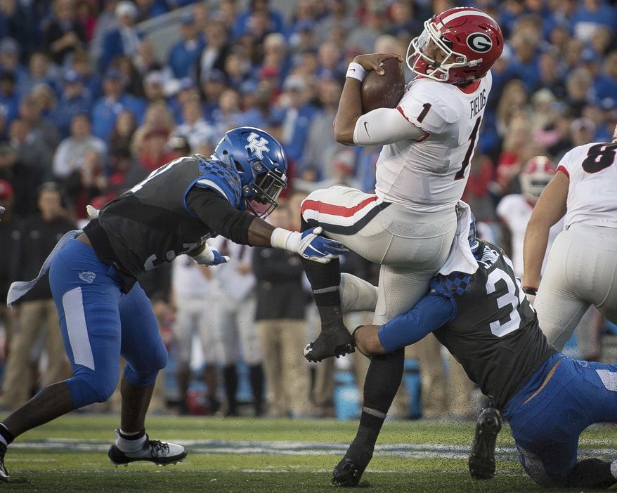 FILE - In this Nov. 3, 2018, file photo, Georgia quarterback Justin Fields (1) is tackled by Kentucky linebacker Jordan Jones (34) and linebacker Jamar Watson (31) during the second half an NCAA college football game in Lexington, Ky. “Of course, not having them, it's a difference,” Watson said of his predecessors, who many of whom could be selected in the NFL draft. “But that gives us a lot of confidence going into the season that coach (Mark) Stoops and the rest of defensive staff can groom us and take that step.” (AP Photo/Bryan Woolston, File)