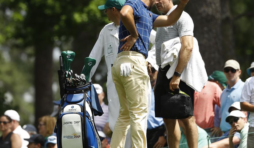 Jason Day, of Australia, holds his back on the fourth tee during the first round for the Masters golf tournament Thursday, April 11, 2019, in Augusta, Ga. (AP Photo/Matt Slocum)