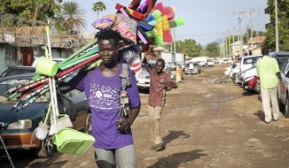 In this photo taken Thursday, April 11, 2019, a young merchant carrying brooms to sell walks along a street after the recent ousting of Sudan&#39;s President Omar al-Bashir, in the capital Juba, South Sudan. The military overthrow of Sudan&#39;s longtime president quickly has raised concerns about whether the upheaval will destabilize neighbouring South Sudan&#39;s fragile efforts at peace after five years of civil war. (AP Photo/Sam Mednick)