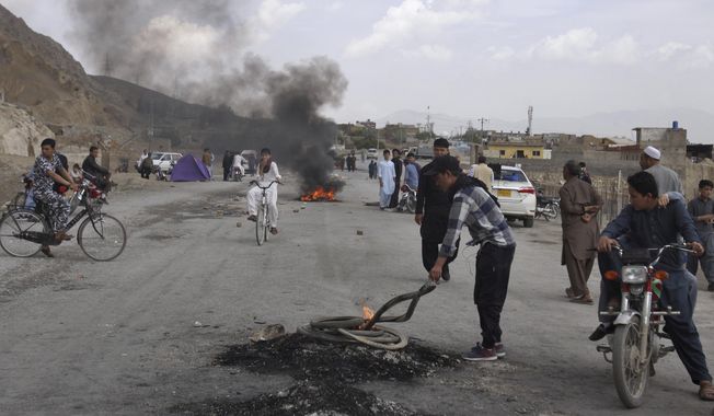 Pakistani Shiite youth from Hazara community burn tires to block a main road during a protest to condemn Friday&#x27;s suicide bombing, in Quetta, Pakistan, Saturday, April 13, 2019. A suicide bomber targeted an open-air market in the southwestern Pakistani city of Quetta on Friday, killing many people and wounding dozens of others, police and hospital officials said. (AP Photo/Arshad Butt)