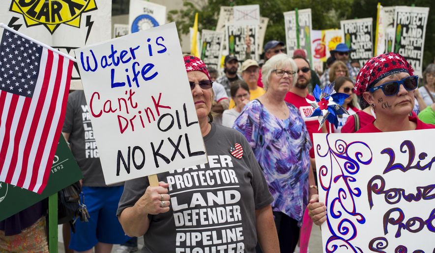 FILE - In this Aug. 6, 2017 file photo, demonstrators against the Keystone XL pipeline listen to speakers in Lincoln, Neb. Eager to jump-start the stalled Keystone XL oil pipeline and other energy projects, President Donald Trump has moved to assert presidential power over pipelines and other infrastructure. (AP Photo/Nati Harnik, File)
