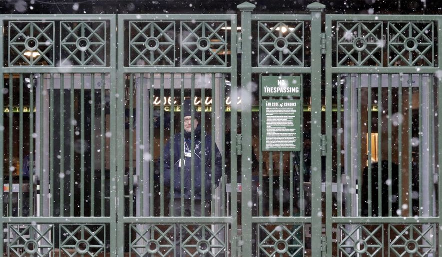 A security guard looks to outside from Wrigley Field, Sunday, April 14, 2019, in Chicago. The Chicago Cubs baseball game against the Los Angeles Angels was postponed due to inclement weather. The makeup date is yet to be determined. (AP Photo/Nam Y. Huh)