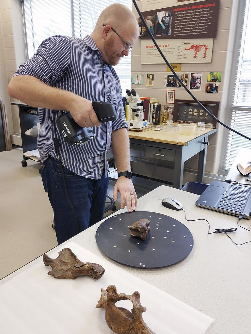 Gary Motz, Indiana Geological and Water Survey Assistant Director for Information Services, uses a 3D scanner to capture images of one of three remaining sloth bones, at the Indiana State Museum in Indianapolis, Feb, 19, 2019. Indiana University is planning to build a replica of giant ground sloth's skeleton that was once a star attraction in its natural history collection but which was tossed out to make room for students during an enrollment surge following World War II. (Indiana University is planning to build a replica of giant ground sloth's skeleton that was once a star attraction in its natural history collection but which was tossed out to make room for students during an enrollment surge following World War II. (Polly Sturgeon/Indiana Geological and Water Survey via AP)