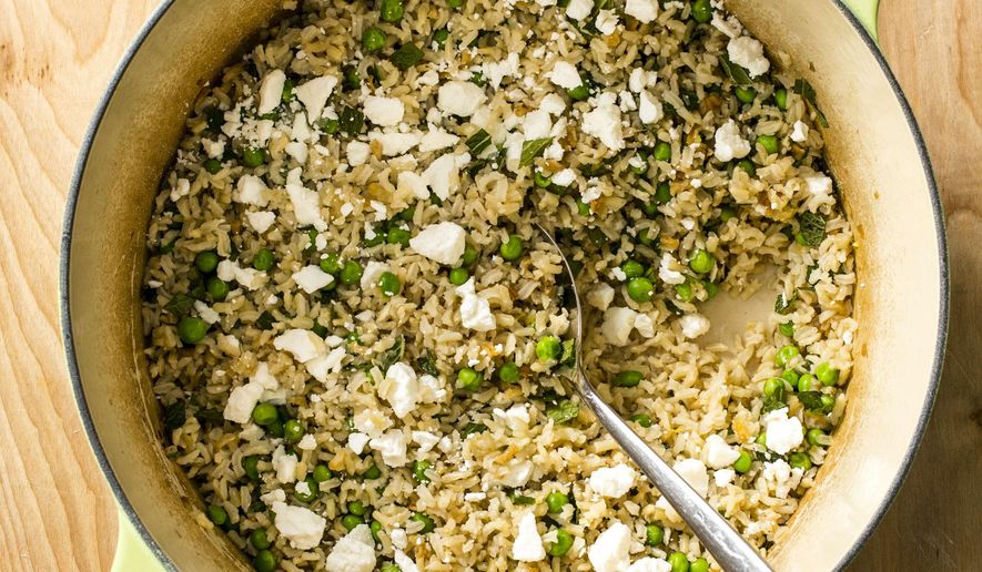 This undated photo provided by America's Test Kitchen in April 2019 shows Brown Rice Pilaf with Peas, Feta and Mint in Brookline, Mass. This recipe appears in the book “Cook It in Your Dutch Oven.” (Steve Klise/America's Test Kitchen via AP)