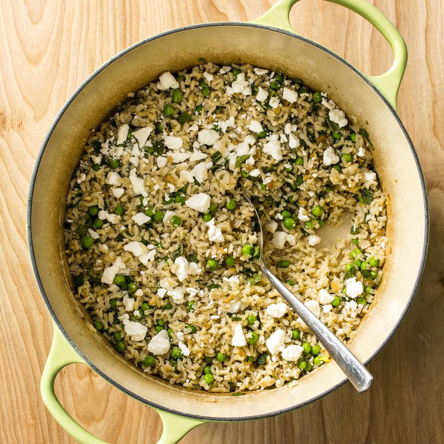 This undated photo provided by America's Test Kitchen in April 2019 shows Brown Rice Pilaf with Peas, Feta and Mint in Brookline, Mass. This recipe appears in the book “Cook It in Your Dutch Oven.” (Steve Klise/America's Test Kitchen via AP)