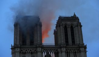 Smoke and flames fill the sky as a fire burns at the Notre Dame Cathedral during the visit by French President Emmanuel Macron in Paris, Monday, April 15, 2019. A catastrophic fire engulfed the upper reaches of Paris&#x27; soaring Notre Dame Cathedral as it was undergoing renovations Monday, threatening one of the greatest architectural treasures of the Western world as tourists and Parisians looked on aghast from the streets below.(Philippe Wojazer/Pool via AP)