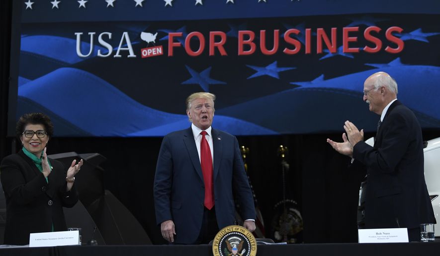 President Donald Trump, center, arrives to speak during a roundtable discussion at Nuss Truck and Equipment in Burnsville, Minn., Monday, April 15, 2019. He is flanked by Jovita Carranza, left, current treasurer at the Department of the Treasury, and Nuss Truck and Equipment President Bob Nuss, right. (AP Photo/Susan Walsh)