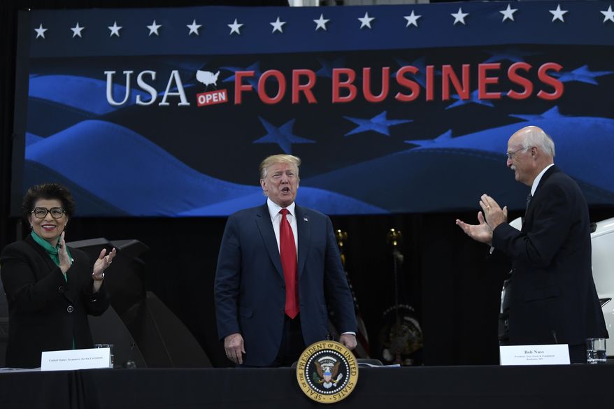 President Donald Trump, center, arrives to speak during a roundtable discussion at Nuss Truck and Equipment in Burnsville, Minn., Monday, April 15, 2019. He is flanked by Jovita Carranza, left, current treasurer at the Department of the Treasury, and Nuss Truck and Equipment President Bob Nuss, right. (AP Photo/Susan Walsh)