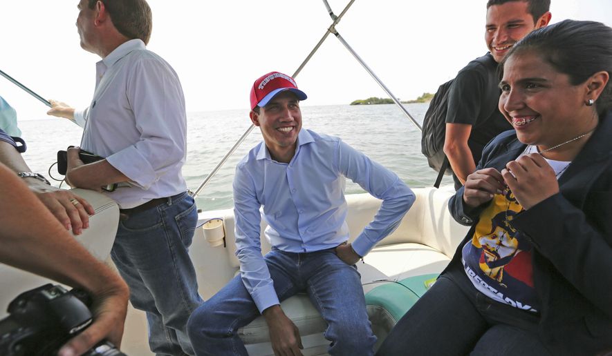 Juan Guaidó, opposition leader and self-proclaimed interim president of Venezuela, sits on a boat with staff members before crossing Maracaibo Lake to reach the town of Cabimas, Venezuela where he will lead a rally, Sunday, April 14, 2019. Guaidó was forced to take the boat in order to outmaneuver police roadblocks and reach throngs of supporters waiting to hear him speak. (AP Photo/Fernando Llano)