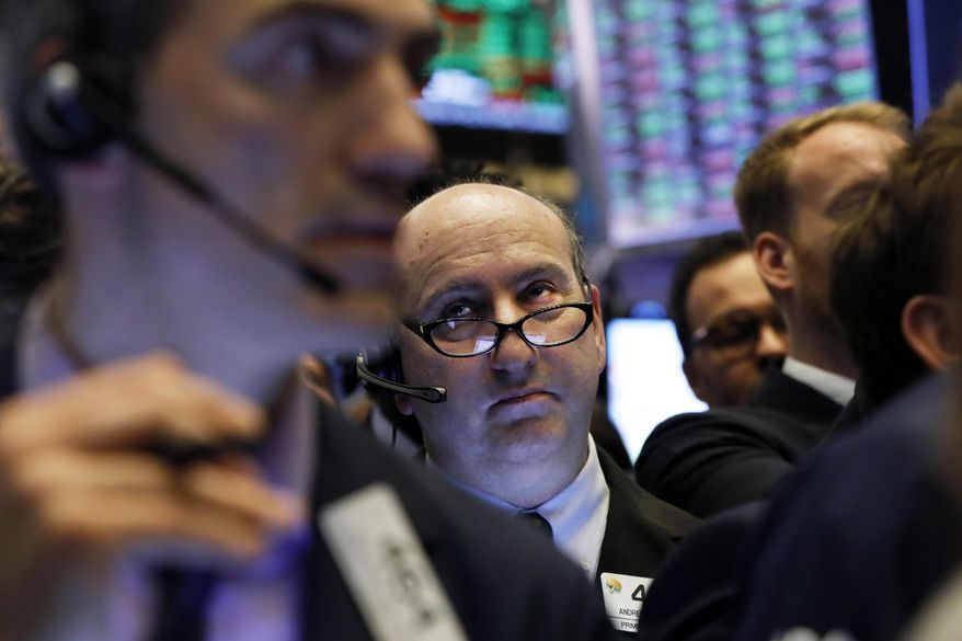 FILE - In this April 12, 2019, file photo trader Andrew Silverman, center, works on the floor of the New York Stock Exchange. The U.S. stock market opens at 9:30 a.m. EDT on Tuesday April 16. (AP Photo/Richard Drew, File)