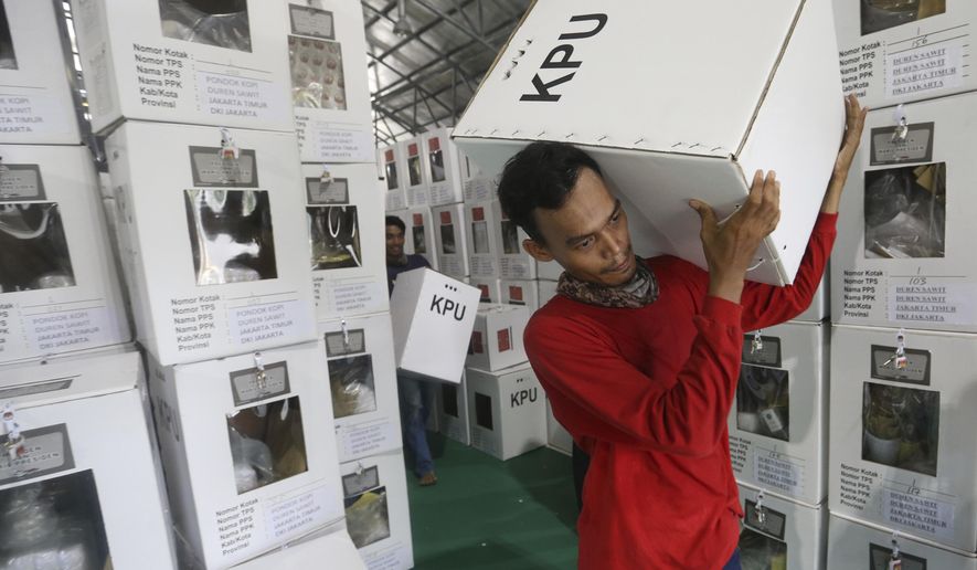 Workers carry ballot boxes to be distributed to polling stations in Jakarta, Indonesia, Tuesday, April 16, 2019. Nearly 193 million Indonesians are eligible to vote in presidential and legislative elections on Wednesday. President Joko Widodo, the first Indonesian president from outside the Jakarta elite, is competing against Prabowo Subianto, a former special forces general from the era of authoritarian rule under military dictator Suharto.(AP Photo/Achmad Ibrahim)
