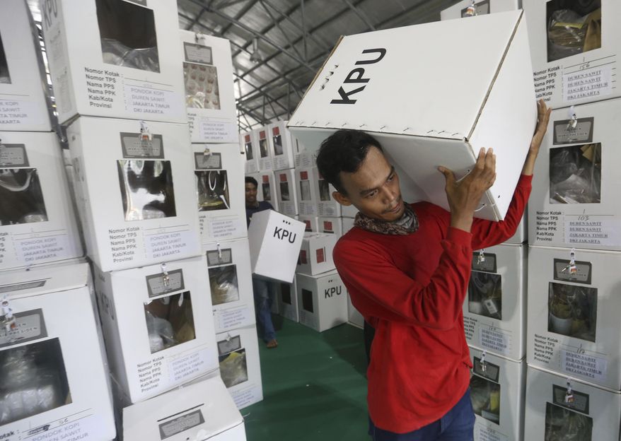 Workers carry ballot boxes to be distributed to polling stations in Jakarta, Indonesia, Tuesday, April 16, 2019. Nearly 193 million Indonesians are eligible to vote in presidential and legislative elections on Wednesday. President Joko Widodo, the first Indonesian president from outside the Jakarta elite, is competing against Prabowo Subianto, a former special forces general from the era of authoritarian rule under military dictator Suharto.(AP Photo/Achmad Ibrahim)