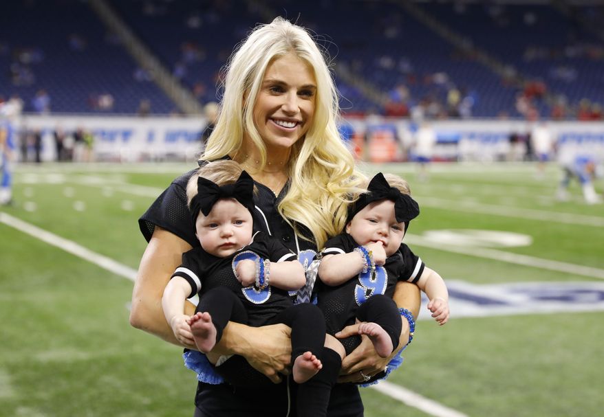 In this Sept. 24, 2017, file photo, Kelly Stafford, wife of Detroit Lions quarterback Matthew Stafford, holds the couple's twins Sawyer, left, and Chandler during pre-game of an NFL football game against the Atlanta Falcons, in Detroit. Kelly Stafford plans to have surgery to remove a brain tumor. Stafford shared the details Wednesday, April 3, 2019, on her Instagram account. She says an MRI showed the tumor on cranial nerves after she had vertigo spells within the last year. (AP Photo/Rick Osentoski, File)