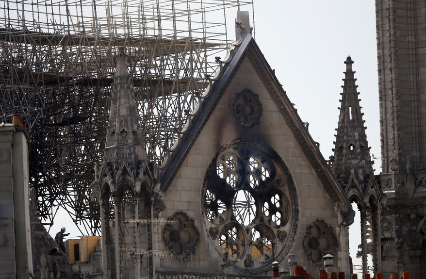 A worker checks on a wooden support structure placed on the Notre Dame Cathedral in Paris, Wednesday, April 17, 2019. Nearly $1 billion has already poured in from ordinary worshippers and high-powered magnates around the world to restore Notre Dame Cathedral in Paris after a massive fire. (AP Photo/Francois Mori)