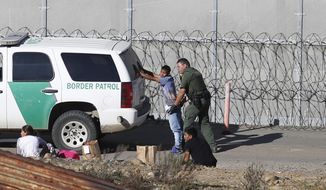 In this Dec. 15, 2018, file photo, Honduran asylum seekers are taken into custody by U.S. Border Patrol agents after the group crossed the U.S. border wall into San Diego, Calif., seen from Tijuana, Mexico. Facing high turnover, the Border Patrol is instituting a 5% retention bonus in the fall of 2019 to incentivize agents to remain with the service. (AP Photo/Moises Castillo, File) **FILE**