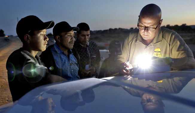 A U.S. Customs and Border Patrol agent gathers information on four Guatemalan nationals, including two men and a pair of 12 and 13-year-old boys in Yuma, Ariz. Yuma Mayor Douglas Nicholls has declared a state of emergency to deal with the number of families being released from Border Patrol custody into the city. Nicholls said Tuesday, April 16, 2019, that he had hoped not to get to this point but that the organizations helping immigrant families just don&#x27;t have the capacity to deal with so many. (AP Photo/Matt York) **FILE**
