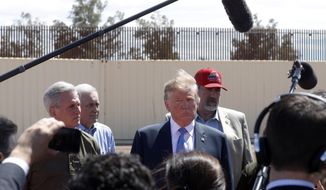 FILE - In this April 5, 2019, file photo, President Donald Trump visits a new section of the border wall with Mexico in Calexico, Calif. When Trump insisted last year that the border was in crisis, his warnings landed with a thud. Now, as the situation at the border has deteriorated to a level of alarm, Trump is again being met with skepticism, even as members on both sides of the aisle agree that there is a legitimate humanitarian emergency, with federal authorities and non-profits unable to cope with the influx of tens of thousands of Central American families seeking refuge in the U.S. (AP Photo/Jacquelyn Martin, File)