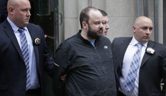Marc Lamparello, 37, center, is escorted out of a police precinct in New York, Thursday, April 18, 2019.  Police say Lamparello was arrested after entering St. Patrick&#39;s Cathedral Wednesday night in New York with two cans of gasoline, lighter fluid and butane lighters. Lamparello is facing charges including attempted arson and reckless endangerment. (AP Photo/Seth Wenig)