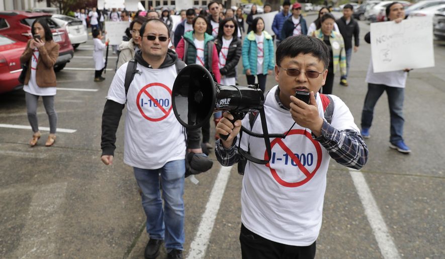 Protesters opposed to Initiative 1000 chant and march following a joint Washington state House and Senate committee, Thursday, April 18, 2019, at the Capitol in Olympia, Wash. Several members of the group spoke in opposition to Initiative 1000, which would allow the state government to use affirmative action policies that do not constitute preferential treatment to remedy discrimination in public employment, education and contracting. (AP Photo/Ted S. Warren)