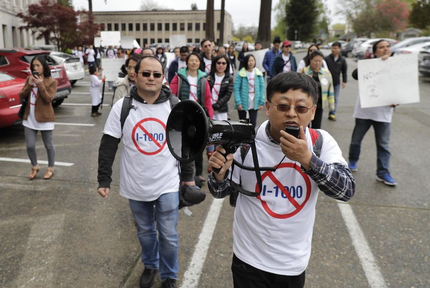 Protesters opposed to Initiative 1000 chant and march following a joint Washington state House and Senate committee, Thursday, April 18, 2019, at the Capitol in Olympia, Wash. Several members of the group spoke in opposition to Initiative 1000, which would allow the state government to use affirmative action policies that do not constitute preferential treatment to remedy discrimination in public employment, education and contracting. (AP Photo/Ted S. Warren)