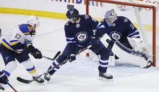 St. Louis Blues&#39; Jaden Schwartz (17) scores the against Winnipeg Jets goaltender Connor Hellebuyck (37) as Jets&#39; Jacob Trouba (8) defends in the final minute of Game 5 of an NHL hockey first-round playoff series Thursday, April 18, 2019, in Winnipeg, Manitoba. (John Woods/The Canadian Press via AP)
