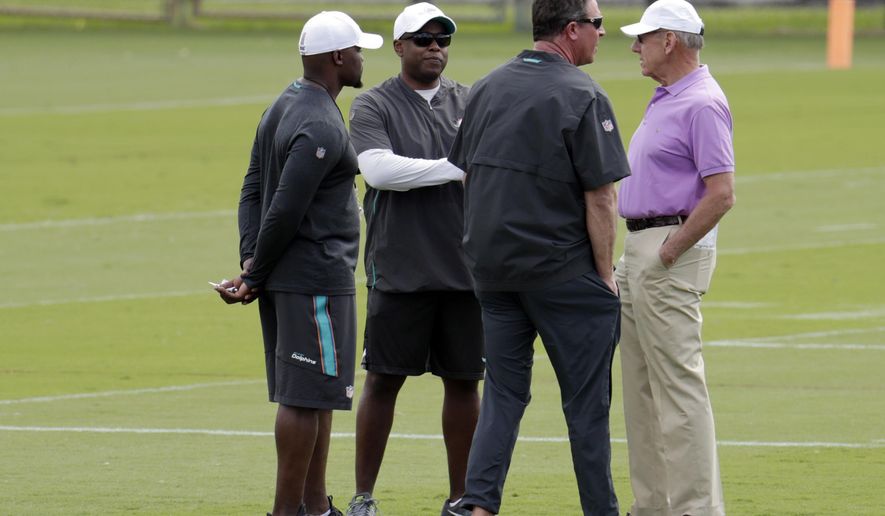 Miami Dolphins head coach Brian Flores, left, general manager Chris Grier, second from left, former quarterback Dan Marino, and owner Stephen Ross, right, talk on the field during voluntary minicamp at the Miami Dolphins NFL football training facility, Wednesday, April 17, 2019, in Davie, Fla. (AP Photo/Lynne Sladky)