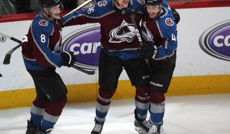 Colorado Avalanche right wing Mikko Rantanen, center, celebrates his overtime goal with defensemen Cale Makar, left, and Tyson Barrie in Game 4 of an NHL hockey playoff series against the Calgary Flames on Wednesday, April 17, 2019, in Denver. The Avalanche won 3-2. (AP Photo/David Zalubowski)