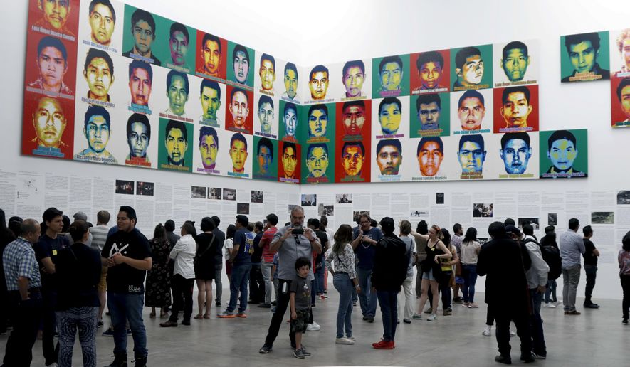 People stand under the portraits of 43 college students who went missing in 2014 in an apparent massacre, by Chinese concept artist and government critic Ai Weiwei at the Contemporary Art University Museum (MUAC ) in Mexico City, Mexico, Saturday, April 13, 2019. Each portrait in the work of art titled &amp;quot;Reestablish Memories&amp;quot; is made out of lego blocks. (AP Photo/Claudio Cruz)