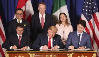 In this Nov. 30, 2018, file photo, President Donald Trump, center, sits between Canada&#39;s Prime Minister Justin Trudeau, right, and Mexico&#39;s President Enrique Pena Nieto as they sign a new United States-Mexico-Canada Agreement that is replacing the NAFTA trade deal, during a ceremony at a hotel before the start of the G-20 summit in Buenos Aires, Argentina. Mr. Trump’s new North America trade agreement would give the U.S. economy only a modest boost, an independent federal agency finds. (AP Photo/Martin Mejia, File)