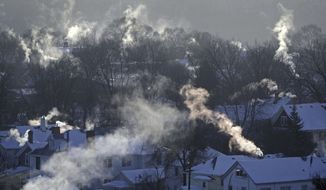 FILE- In this Wednesday Jan. 30, 2019, file photo smoke rises from the chimneys of homes in St. Paul, Minn. Americans burned a record amount of energy in 2018, with a 10% jump in consumption from booming natural gas helping to lead the way, the U.S. Energy Information Administration says. Overall consumption of all kinds of fuels rose 4% year on year, the largest such increase in eight years, a report this week from the agency said. Fossil fuels in all accounted for 80% of Americans’ energy use. (Brian Peterson/Star Tribune via AP, File)