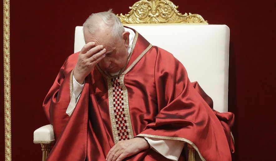 Pope Francis touches his forehead as he celebrates Mass for the Passion of Christ, in St. Peter's Basilica, at the Vatican, Friday, April 19, 2019. Pope Francis began the Good Friday service at the Vatican with the Passion of Christ Mass and hours later will go to the ancient Colosseum in Rome for the traditional Way of the Cross procession. (AP Photo/Alessandra Tarantino)