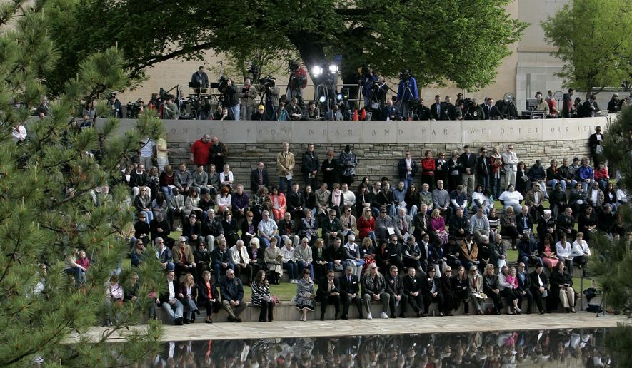 FILE - In this April 19, 2010 file photo, people gather under the Survivor Tree at the Oklahoma City National Memorial during a ceremony marking the 15th anniversary of the Oklahoma City bombing. As part of the city&#x27;s annual day of remembrance Friday, April 19, 2019 – the 24th anniversary of the attack – civic leaders will plant a tree in a city park that was cloned from this scarred American elm that survived the deadliest act of domestic terrorism on U.S. soil. (AP Photo/Sue Ogrocki, File)